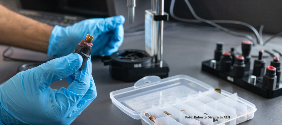 Peritos analisam projéteis em microscópio para compatibilidade balística