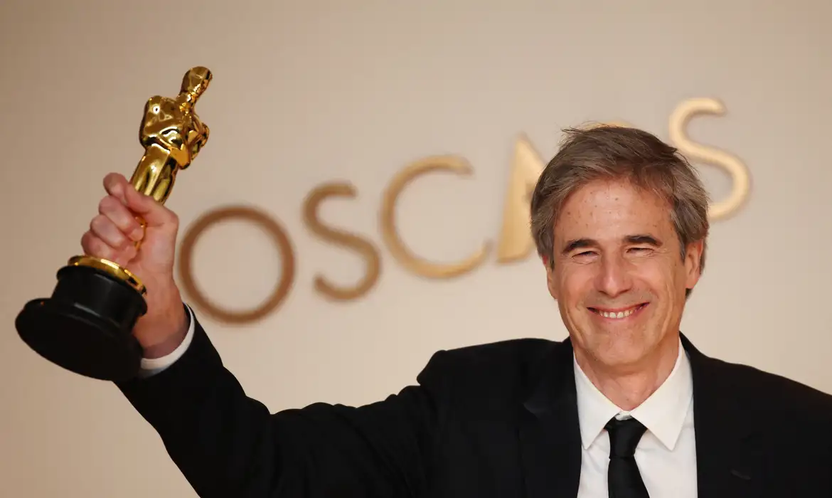 Estatueta do Oscar com fundo dourado, representando a conquista brasileira na premiação de 2025.