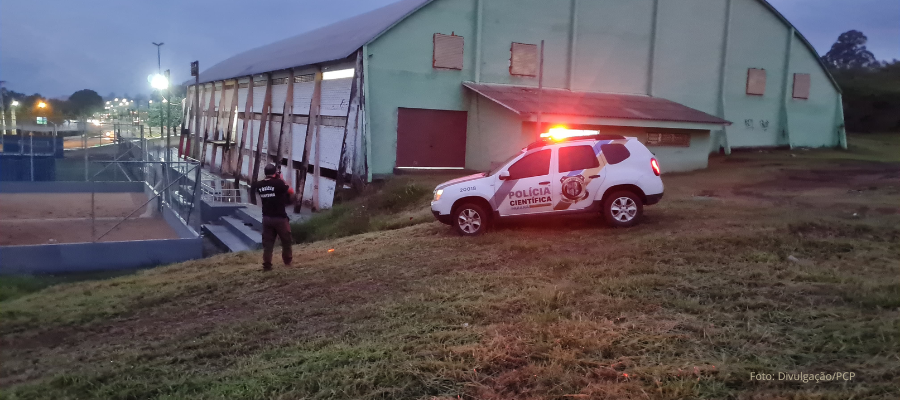 Viatura da Polícia Científica estacionada em frente ao ginásio